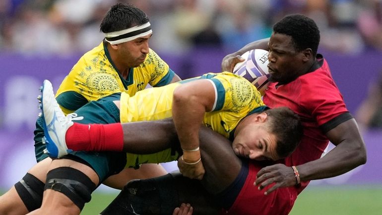 Australia's Nathan Lawson, left, tackles Kenya's Vincent Onyala during the...