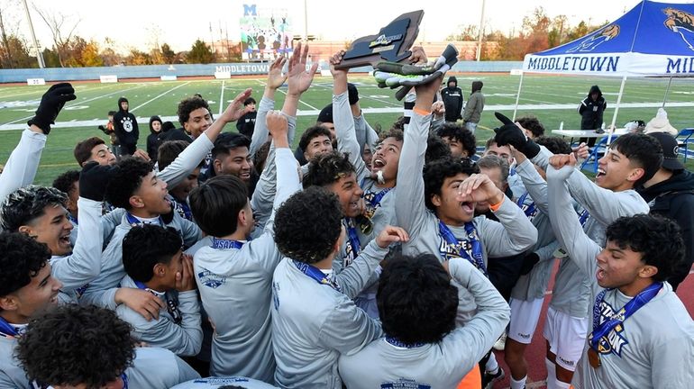 Brentwood players and coaches celebrate with the championship plaque after...