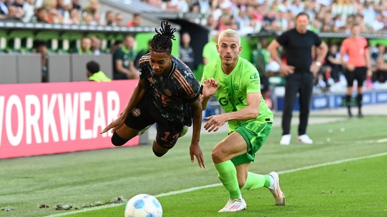 Bayern's Michael Olise, left, in action against Wolfsburg's Jakub Kaminski...