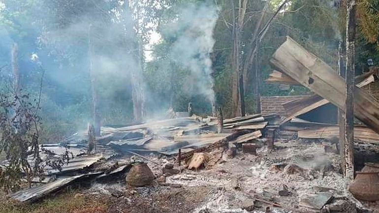 Smoke rises from debris and corrugated roofing of a school...