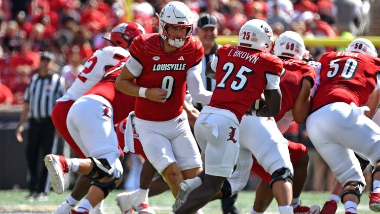 Louisville quarterback Tyler Shough (9) hands the ball off to...