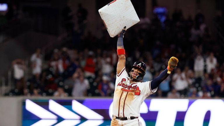 Atlanta Braves' Ronald Acuña Jr. (13) holds up the base...