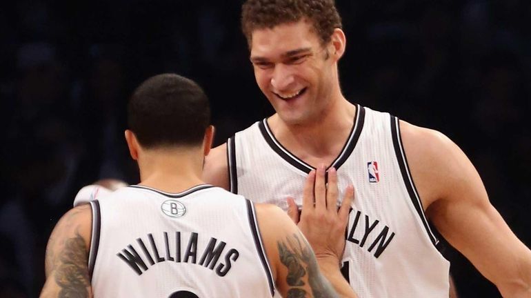 Brook Lopez and Deron Williams celebrate a basket at the...