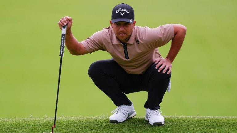 Xander Schauffele lines up a putt on the ninth green...