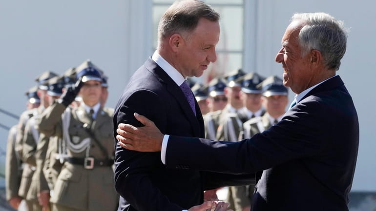 Poland's President Andrzej Duda, left, greets Portuguese President Marcelo Rebelo...