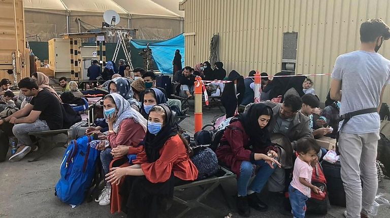 People wait to be evacuated from Afghanistan on Wednesday at Hamid...