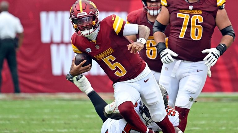 Washington Commanders quarterback Jayden Daniels (5) is stopped by Tampa...