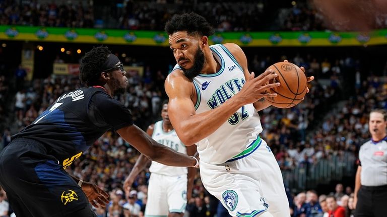 Minnesota Timberwolves center Karl-Anthony Towns, right, drives to the basket...