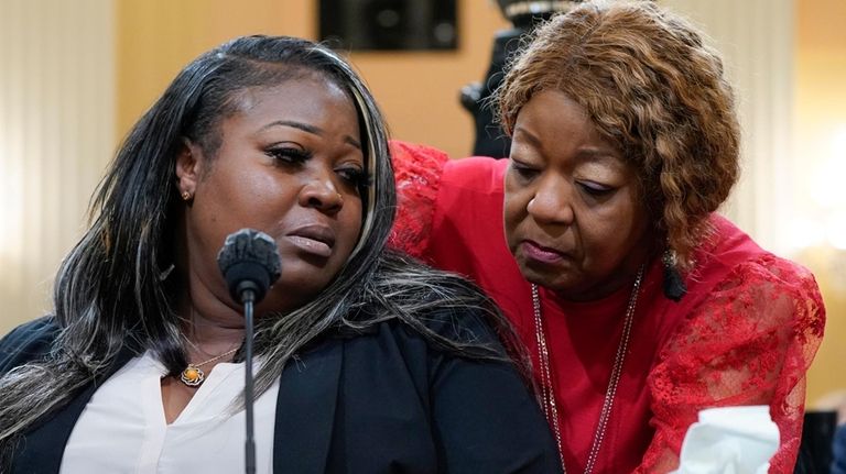 Former Georgia election workers, Wandrea "Shaye" Moss is comforted by...