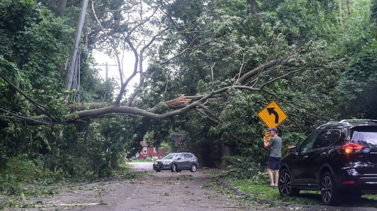 A car passes through damage in East Setauket from Tropical Storm...