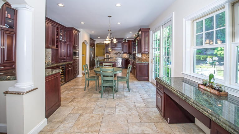 The oversized chef's kitchen has high-end appliances and looks out over...
