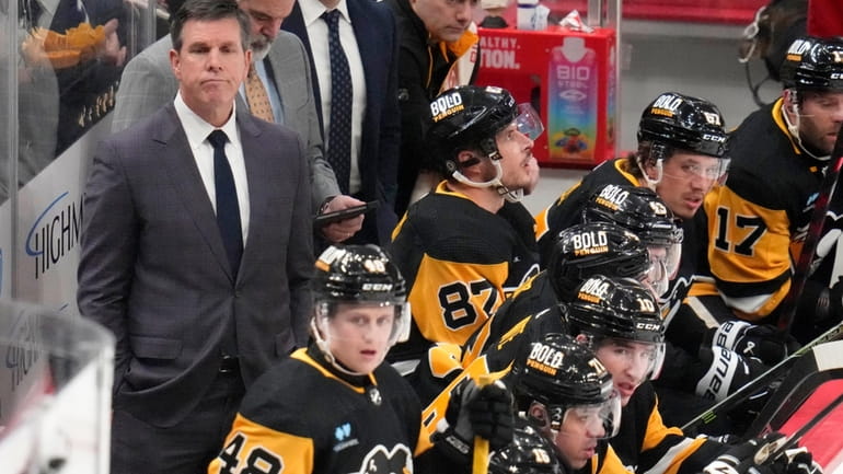 Pittsburgh Penguins head coach Mike Sullivan, left, stands behind his...