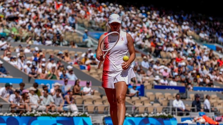 Iga Swiatek of Poland prepares to serve against Qinwen Zheng...