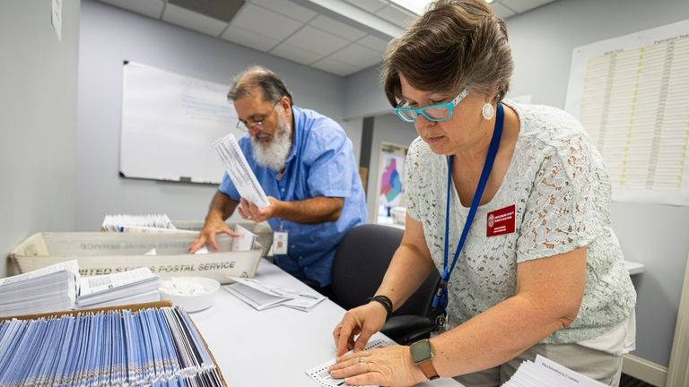 Dawn Stephens, right, and Duane Taylor prepare ballots to be...