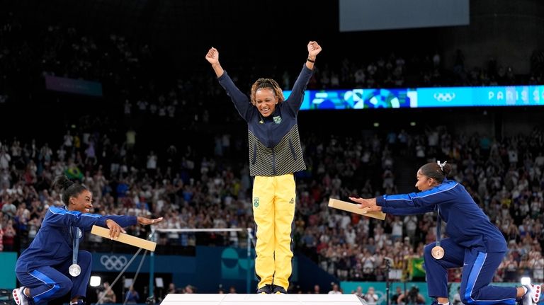 Silver medalist Simone Biles, of the United States, left, and...