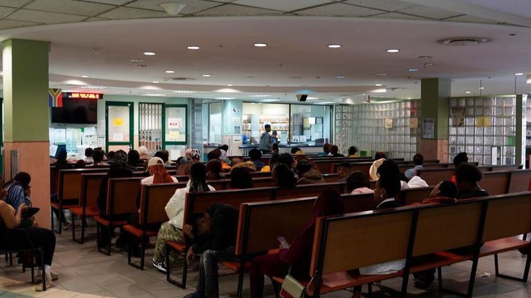 People queue at a government-run health clinic where free HIV...