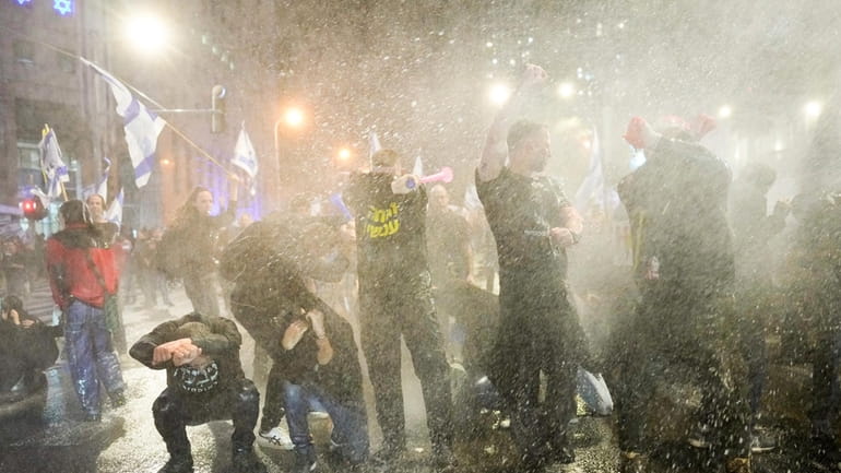 Police use water cannons to disperse demonstrators during a protest...