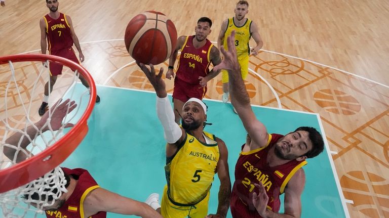 Patty Mills, of Australia, shoots around Alex Abrines, of Spain,...