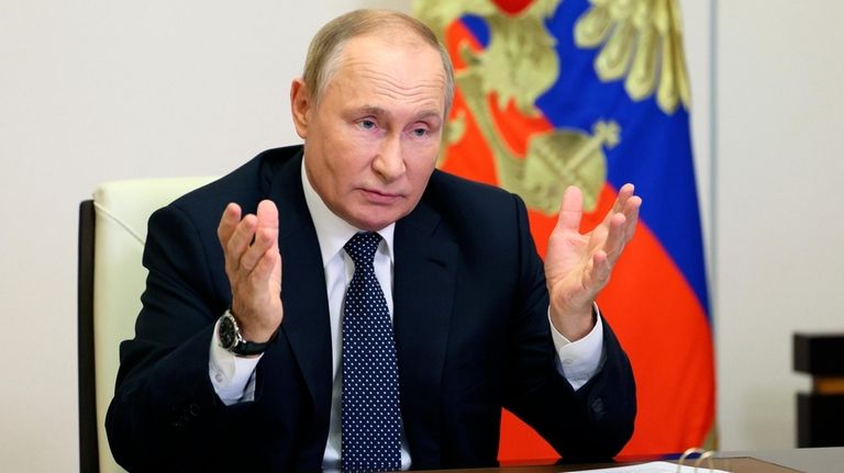 Russian President Vladimir Putin gestures during a meeting with the...