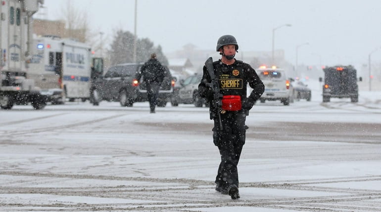 A member of the Colorado Springs sheriff's department secures the...