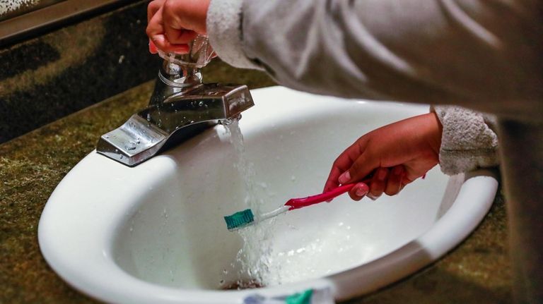 A child rinses a toothbrush in San Francisco on June...