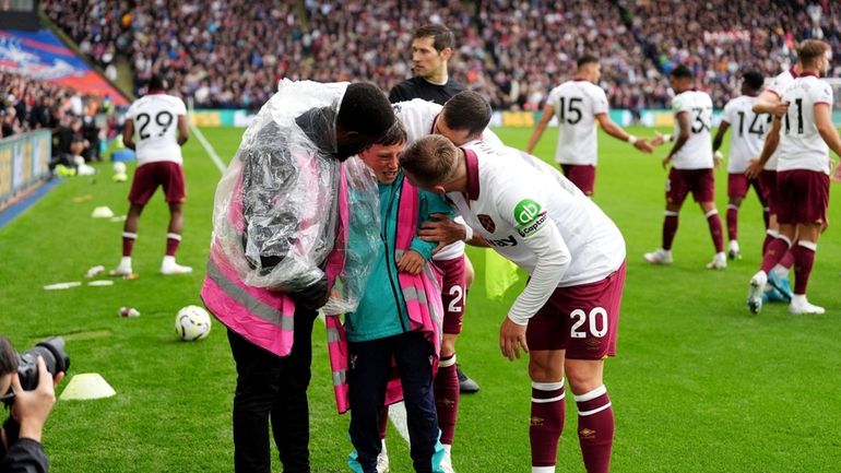 West Ham United's Jarrod Bowen, right, consoles a ball boy...