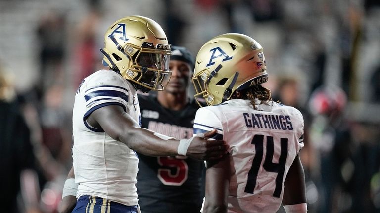 Akron quarterback DJ Irons, left, talks with wide receiver Jasaiah...