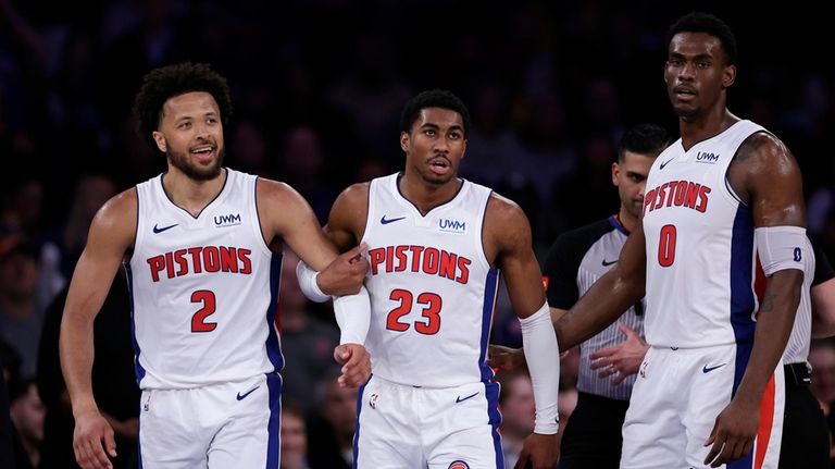 Detroit Pistons guard Cade Cunningham (2) is pulled away by...