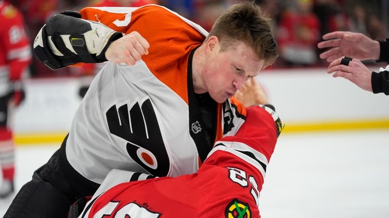 Philadelphia Flyers defenseman Nick Seeler, top, punches Chicago Blackhawks center...