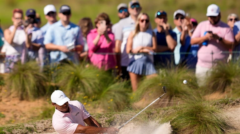 Tiger Woods hits from the bunker on the fifth hole...