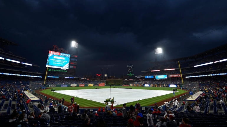 A tarp covers the field before a scheduled game between...