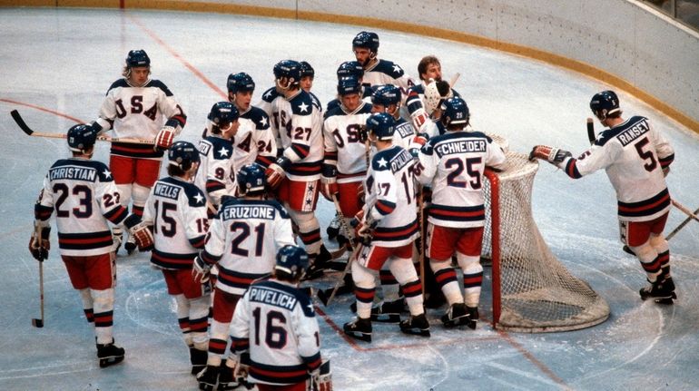 Team USA crowds around winning goalie Jim Craig after defeating...