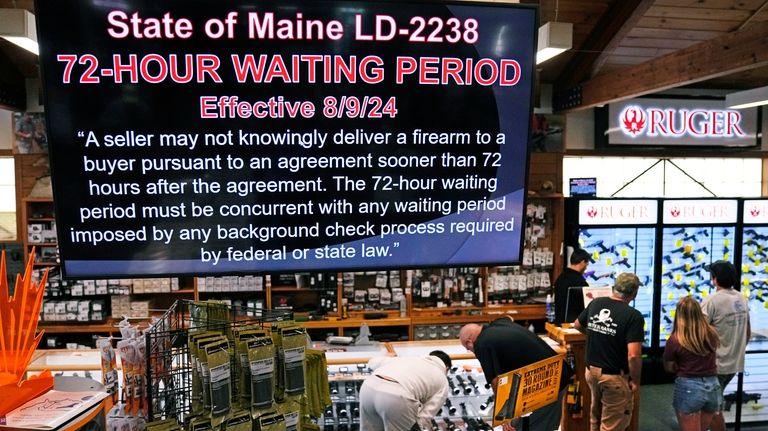 Customers shop in the firearms section at the Kittery Trading...