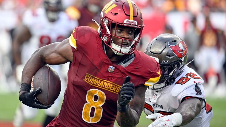 Washington Commanders running back Brian Robinson Jr. (8) runs past...