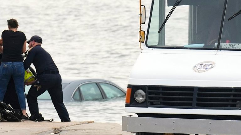 Galveston Police assist in getting a car out of the...