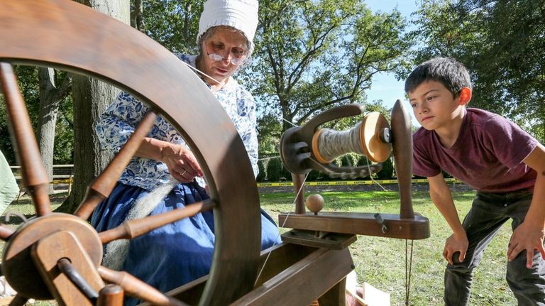 Brandon Guardado, of Inwood, watches as Barbara Beckerman gives a...