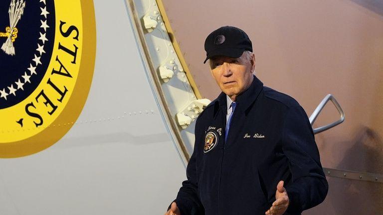 President Joe Biden walks down the steps of Air Force...