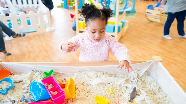 Zianna Smith, 2, of Patchogue, plays at the sand table...