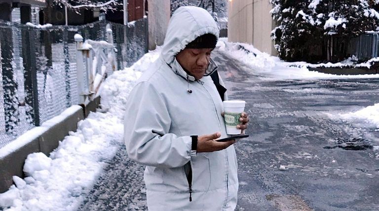 Jesus Grados waits for his bus in Huntington on Monday...