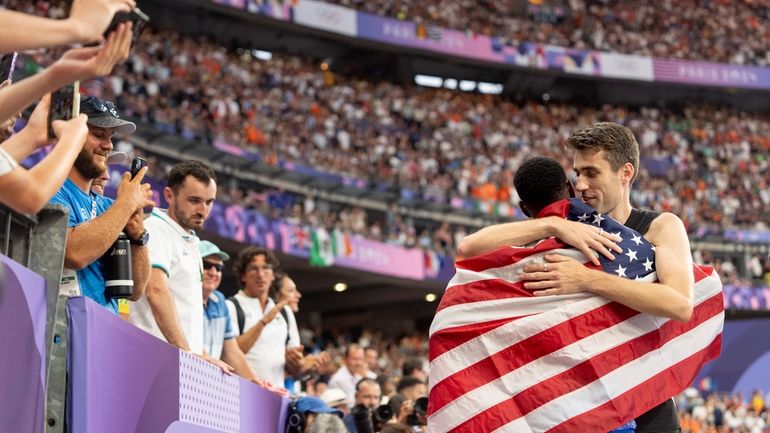 Hamish Kerr, of New Zealand, right, embraces Shelby McEwen, of...