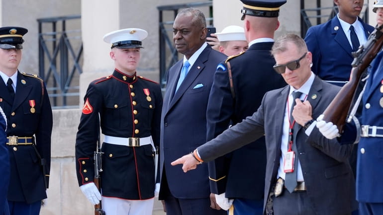 Defense Secretary Lloyd Austin, third left, stands before greeting Kenya's...