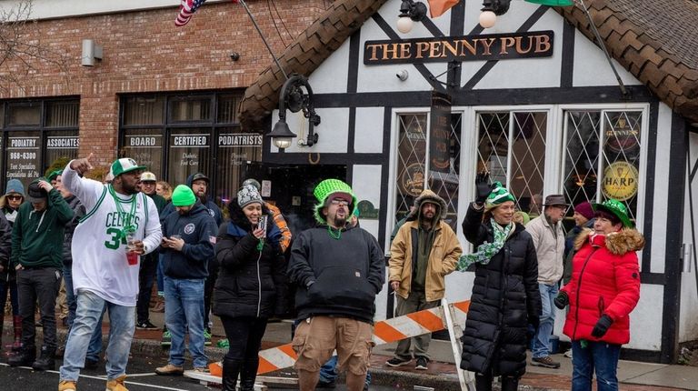 Spectators celebrate and cheer as the St Patrick's Day Parade passes...