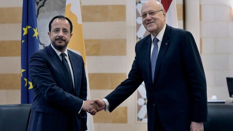 Cyprus' President Nikos Christodoulides, left, shakes hands with Lebanese caretaker...