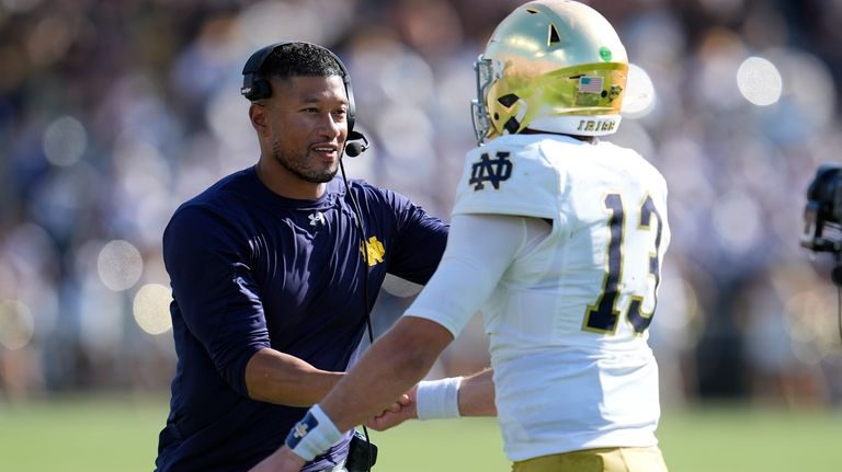 Notre Dame head coach Marcus Freeman congratulates quarterback Riley Leonard...