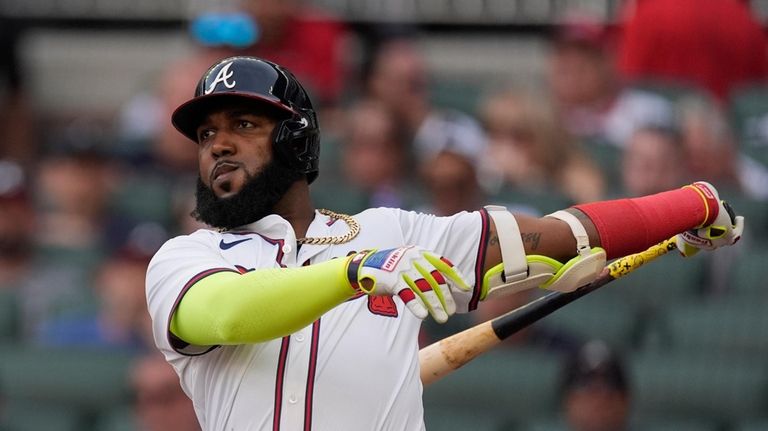 Atlanta Braves designated hitter Marcell Ozuna follows through on a...