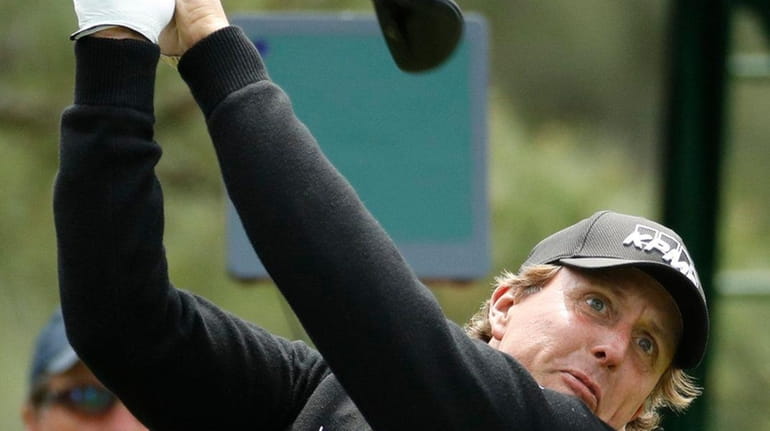 Phil Mickelson hits a drive on the 18th hole during...