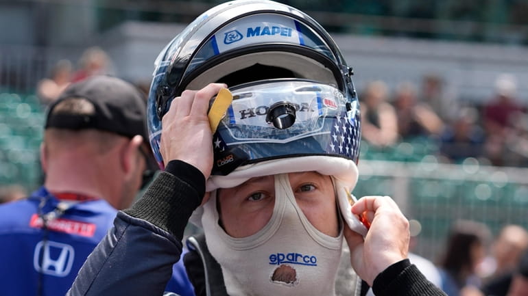 Marco Andretti puts on his helmet during qualifications for the...