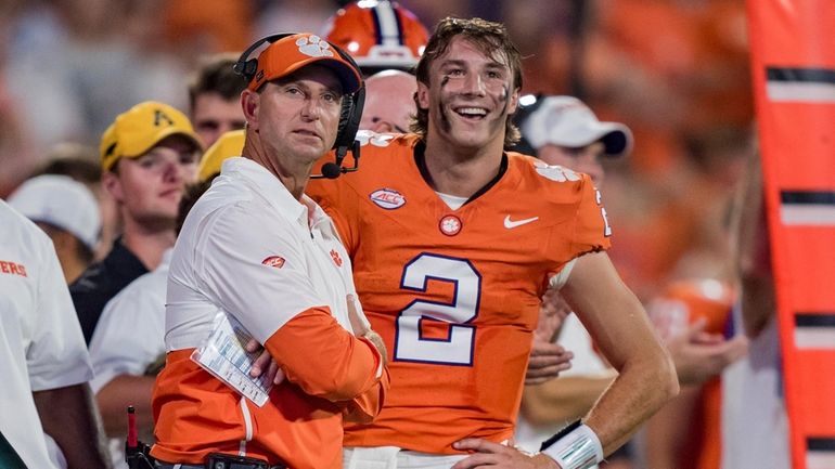 Clemson head coach Dabo Swinney, front left, looks on with...