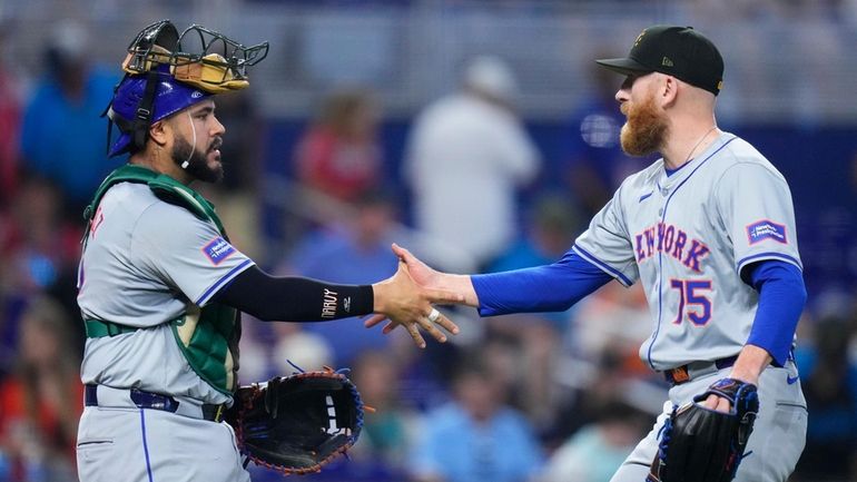 Reed Garrett and Omar Narváez of the Mets celebrate after defeating the...