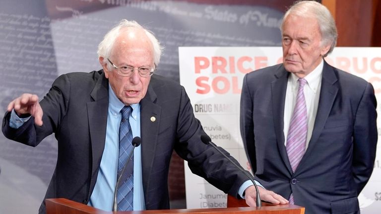 Sen. Bernie Sanders, I-Vt., left, speaks during a news conference...